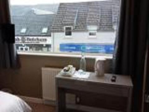 洛哈尔什教区凯尔高地The Skye Bridge Hotel的客房设有一张床和一张桌子,并带有窗户