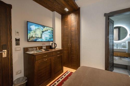 佩奇Hotel - Kulla e Zenel Beut的卧室配有一张床,墙上配有电视