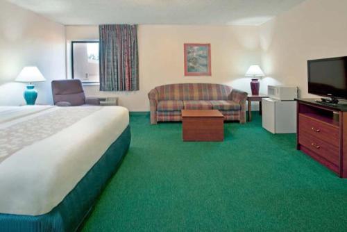 印第安纳波利斯Norwood Inn & Suites Indianapolis East Post Drive的酒店客房配有床、沙发和电视。