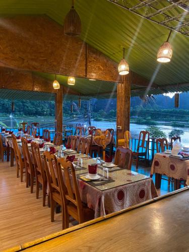 宁平Tam Coc Wonderland Bungalow的一间带桌椅并享有水景的餐厅