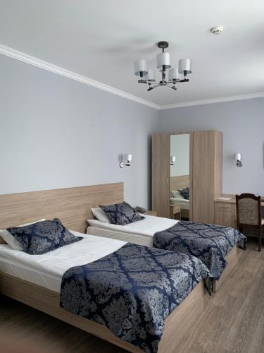 巴甫洛达尔Nurtau的一间卧室配有两张床和镜子