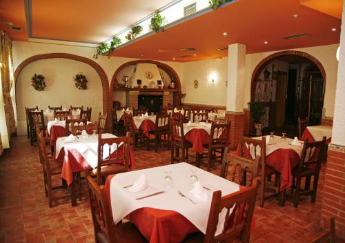 埃赫阿-德洛斯卡瓦列罗斯夸特洛埃斯奎因纳斯旅馆的餐厅配有白色的桌椅和红色的餐巾