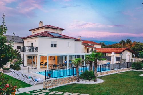 希洛Cool Šilo Appartement Resort的一座带游泳池的大型白色房屋