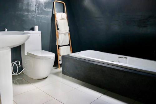LindulaThe ZenDen-Cozy Cabin Perfect For Couples的浴室配有卫生间、盥洗盆和浴缸。