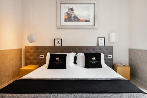 米兰蒙特拿破仑大道套房酒店的一间卧室配有一张带黑白枕头的床