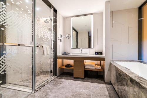 佛山敏卓酒店Mentor Hotel的带淋浴、盥洗盆和浴缸的浴室