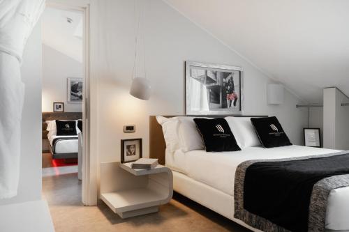 米兰蒙特拿破仑大道套房酒店的卧室配有带黑色枕头的白色床