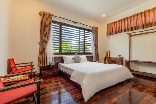 会安Puravida Villa Hoi An 2的卧室配有白色的床和窗户。
