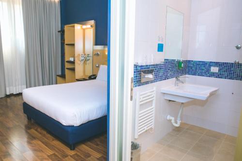 卡萨诺韦米兰马尔彭萨快捷假日酒店的一间卧室配有床、水槽和镜子