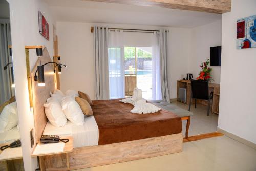 康隆尼角Maison Du Nord的一间卧室配有一张大床、一张桌子和一个窗户。