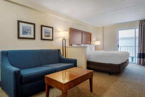 大洋城Comfort Inn Ocean City Boardwalk的酒店客房,配有床和蓝色的沙发