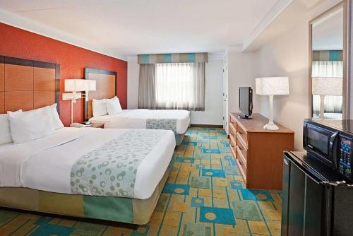 梅里尔维尔Norwood Inn & Suites Merrillville的酒店客房设有两张床和一台平面电视。