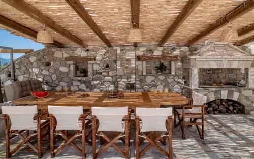 扎金索斯镇Akasha Villa, an Alluring Retreat,By ThinkVilla的用餐室配有大型木桌和椅子