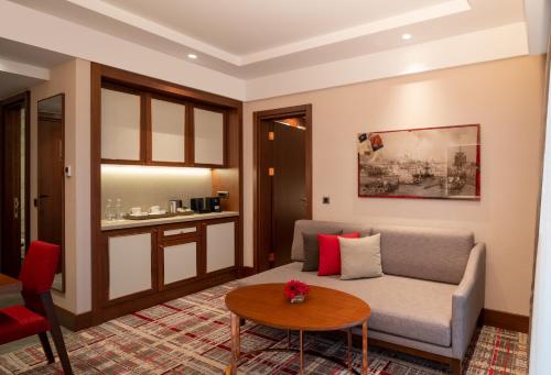 伊斯坦布尔Mövenpick Hotel Istanbul Asia Airport的客厅配有沙发和桌子