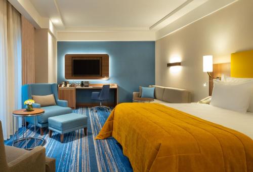 伊斯坦布尔Mövenpick Hotel Istanbul Asia Airport的酒店的客房 - 带一张床、椅子和电视