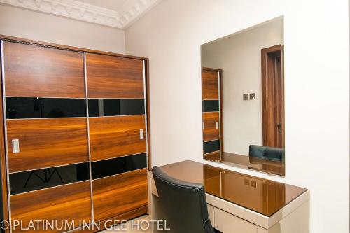 Suru LerePlatinum Inn Gee Hotel的客房设有书桌和大型玻璃柜。