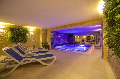 伊斯坦布尔格兰德乌纳尔酒店的一个带游泳池和两张躺椅的房间
