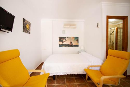 博罗尼亚Apartamentos Turisticos Trajano的一间卧室配有两张黄色椅子和一张床