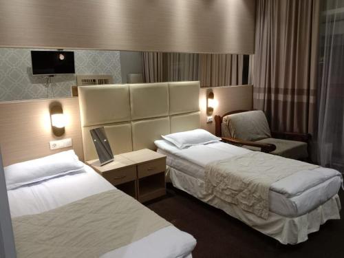 阿斯塔纳Orynbor Boutique Hotel的酒店客房,配有两张床和椅子