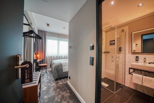 汉诺威NYCE Hotel Hannover的酒店客房设有带床和水槽的浴室