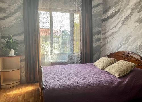 科布列季Bagrationi 54的一间卧室设有紫色的床和窗户