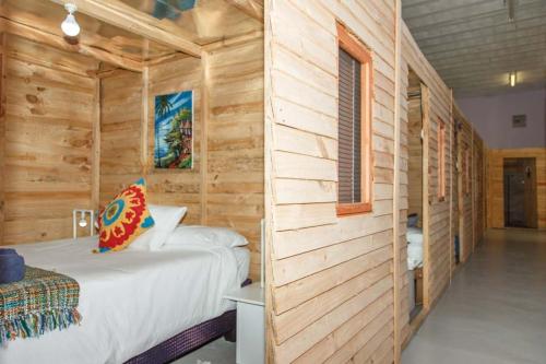 兰伯特湾Bokkomblommetjie的卧室配有木墙内的一张床