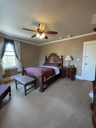 VersaillesThe Woodford Inn的一间卧室配有一张床和吊扇