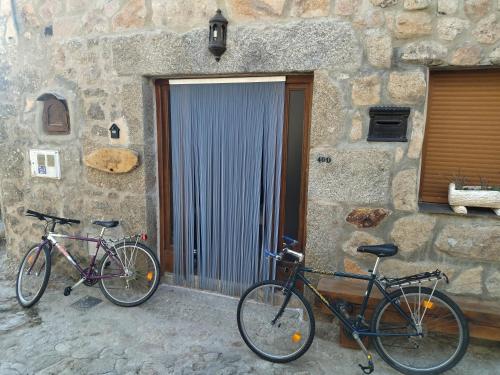 皮尔托贝加El Bosque de los Romanos的两辆自行车停在石头建筑前