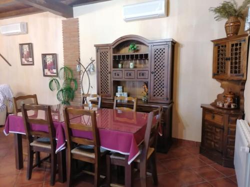 卡塞雷斯Casa rural Suerte de los Mozos的一间用餐室,配有一张紫色的桌子和椅子