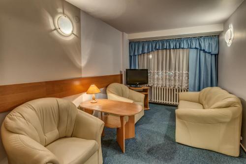 弗沃茨瓦韦克Hotel Kujawy的一间设有两把椅子、一张桌子和一台电视的房间
