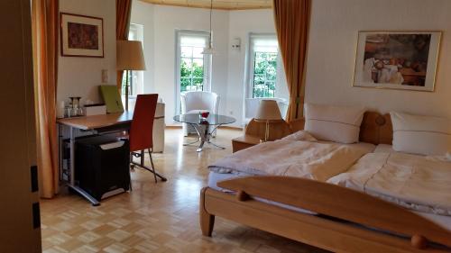 AylWeingut Raevenhof的一间卧室配有一张床、一张桌子和一张桌子
