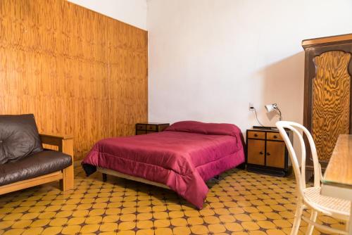 门多萨Alojamiento Aloja N1的一间卧室配有一张床、一把椅子和一张桌子