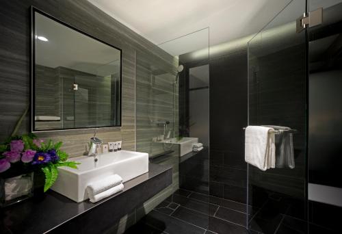 新加坡Venue Hotel The Lily的浴室设有白色水槽和镜子