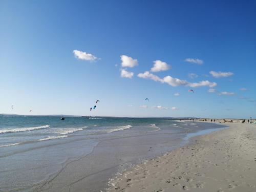兰格班Studio On Fairway的海滩上有人在海洋里放风筝