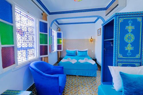 马拉喀什索维拉庭院旅馆的一间卧室配有蓝色的床和蓝色椅子