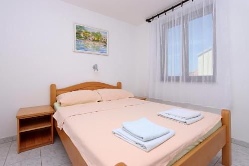 塞尔瑟Apartments and rooms with parking space Selce, Crikvenica - 2362的一间卧室配有一张带白色床单的床和一扇窗户。