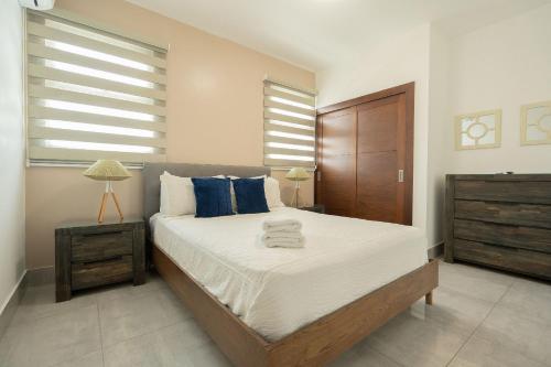 圣地亚哥洛斯卡巴Soha suites I的一间卧室配有一张带蓝色枕头的大床