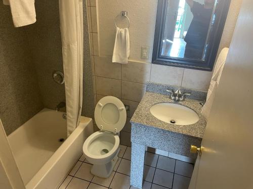 路易斯威尔路易斯维尔汽车旅馆的浴室配有卫生间、盥洗盆和浴缸。
