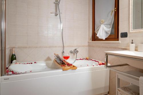 菲乌米奇诺SUITE LEONARDO RELAX的带浴缸和葡萄酒的浴室