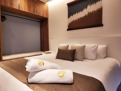 普拉亚卡门Singular Dream Beach Residences的酒店客房,配有带毛巾的床