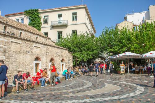 雅典AthINN Residence的一群坐在街上长凳上的人
