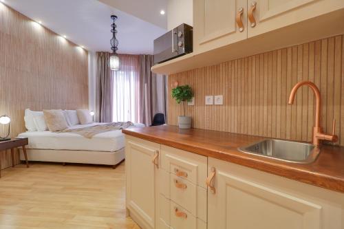 雅典AthINN Residence的一个带水槽的厨房和一张位于客房内的床