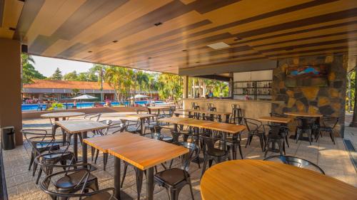 伊瓜苏港堪普勒约美洲酒店的一间空餐厅,配有木桌和椅子