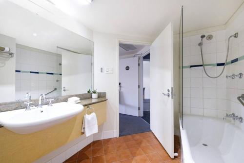 达尔文Resort Style Living in an Oceanview King Suite的一间带水槽、浴缸和淋浴的浴室
