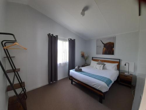 KalganKalgan River Chalets and Caravan Park的卧室配有一张挂有马术图的床铺。