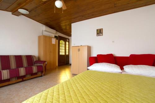 卢卡瓦克Apartment Milna 2461c的一间卧室配有红色的床和一张沙发