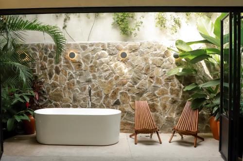 巴亚尔塔港San Trópico Boutique Hotel & Peaceful Escape的带浴缸和两把椅子的浴室