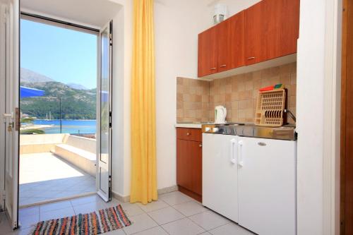 斯拉诺Apartments and rooms by the sea Slano, Dubrovnik - 2687的带水槽的厨房和通往阳台的门