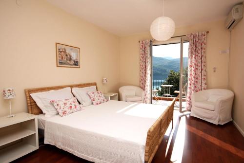 斯拉诺Apartments and rooms by the sea Slano, Dubrovnik - 2681的一间卧室设有一张床和一个美景窗户。