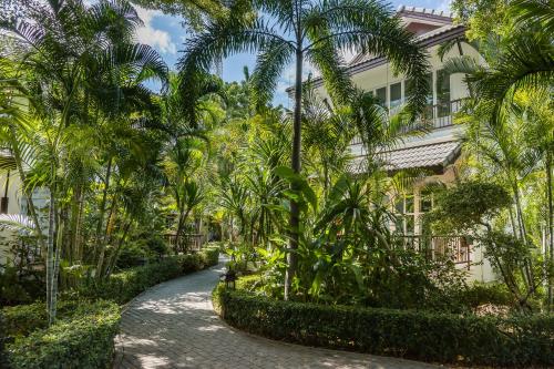 华欣华欣拉萨苏巴度假酒店的一条在建筑前方的棕榈树路径